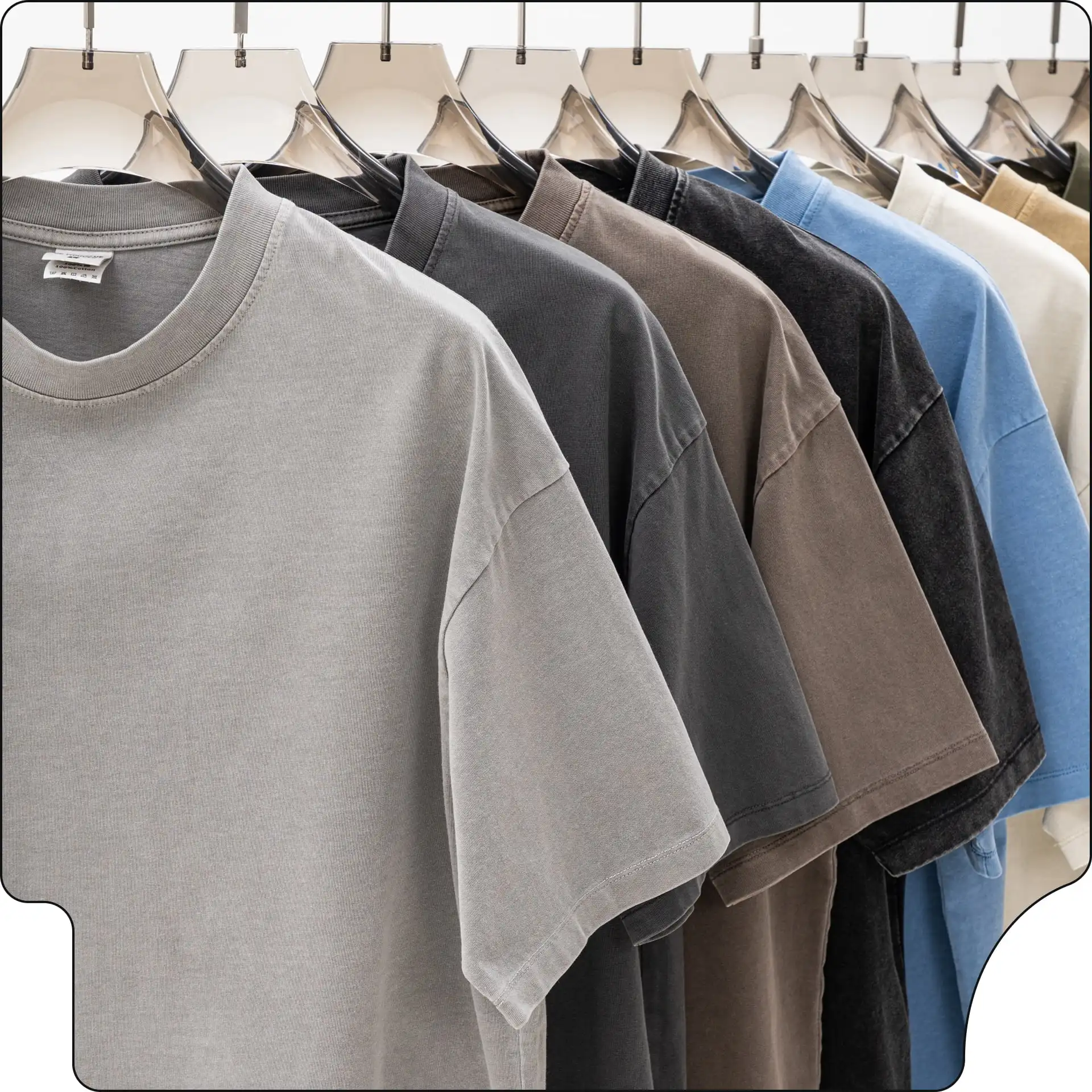 A row of budget-friendly blank T-shirts hanging on a clothing rack in various neutral colors